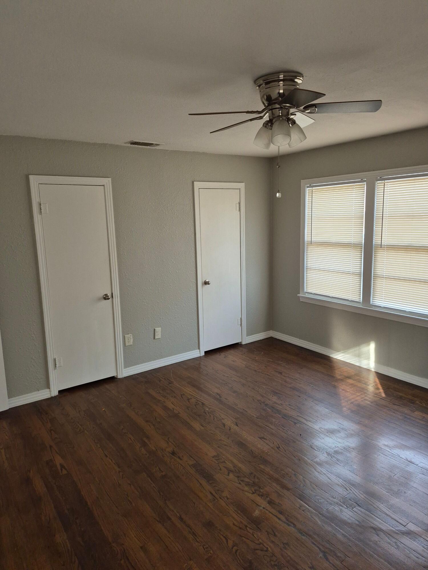 3517 30th Street Lubbock, TX 79410 - Photo 14 of 18 a view of an empty room with wooden floor and a window