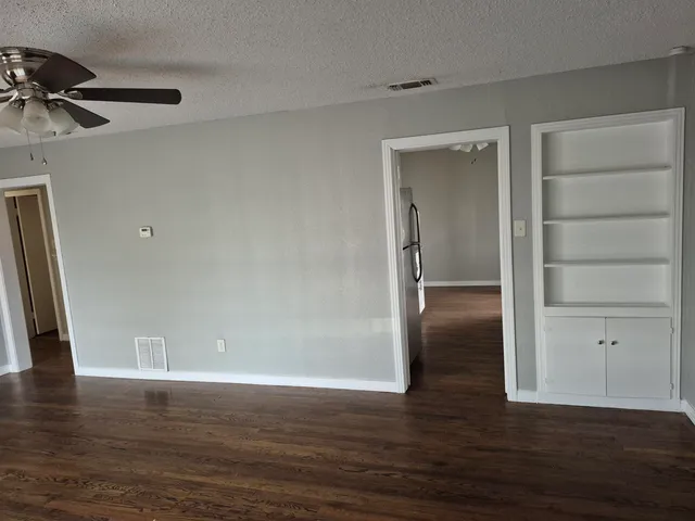 a view of an empty room with wooden floor