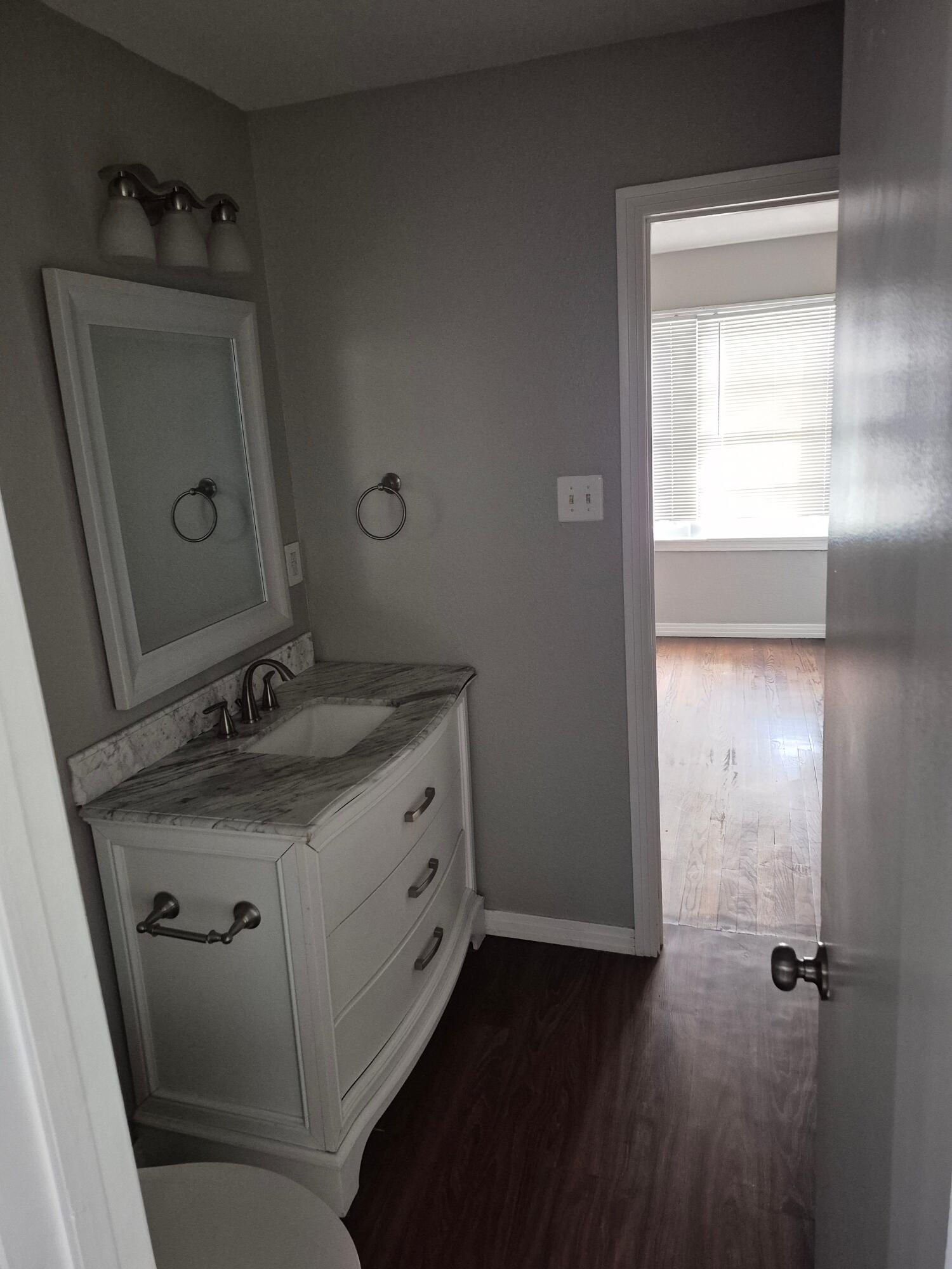 3517 30th Street Lubbock, TX 79410 - Photo 5 of 18 a bathroom with a sink vanity granite and a mirror