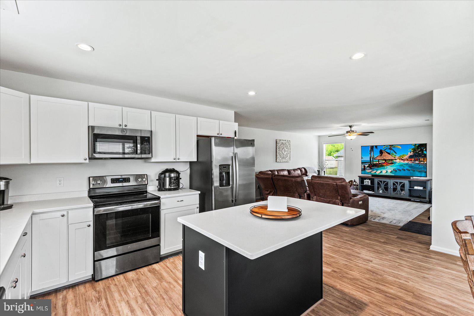 121 1st Street Colonial Beach, VA 22443 - Photo 11 of 46 a kitchen with a stove a microwave and a refrigerator