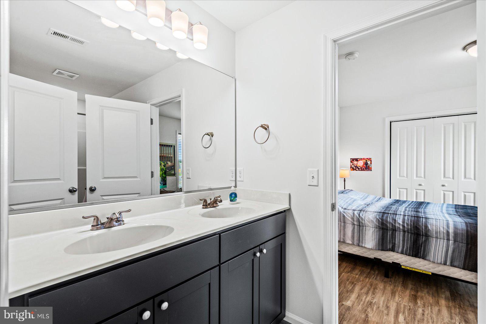 121 1st Street Colonial Beach, VA 22443 - Photo 18 of 46 a en suite bathroom with a double vanity sink and a mirror