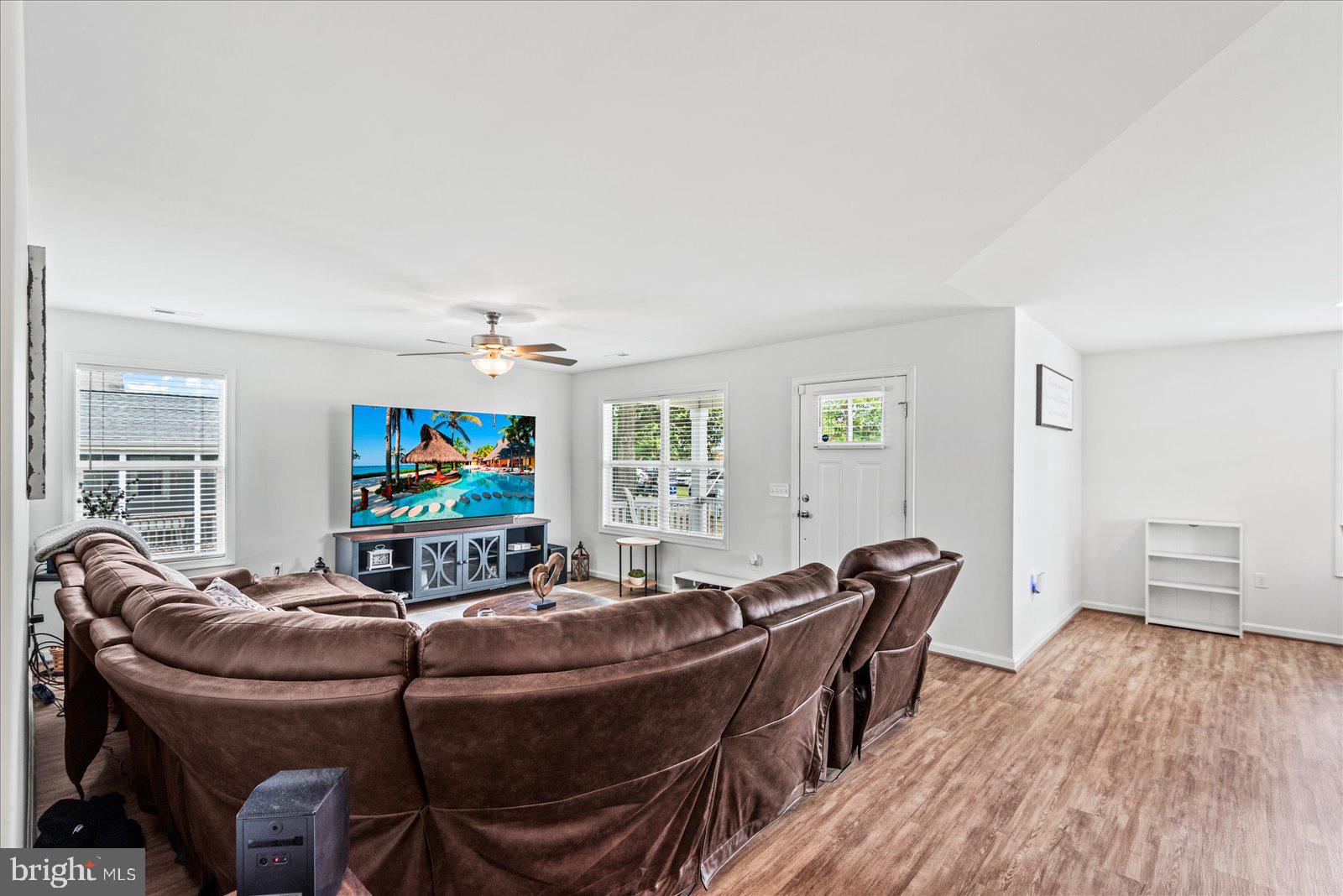 121 1st Street Colonial Beach, VA 22443 - Photo 7 of 46 a living room with furniture a flat screen tv and wooden floor