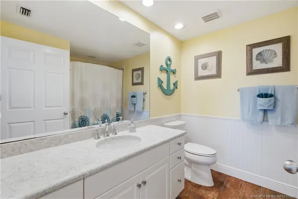 a bathroom with a granite countertop sink mirror and toilet
