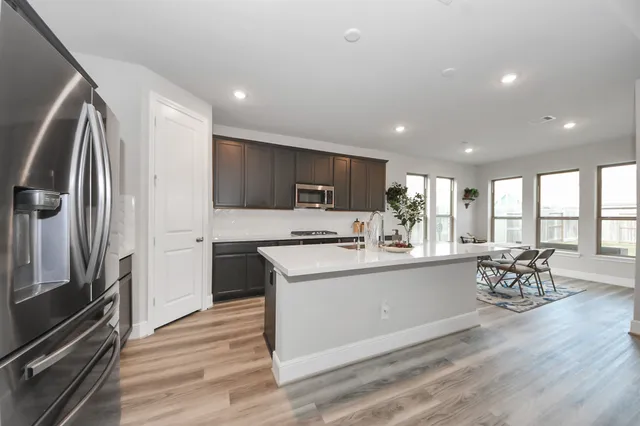 a kitchen with stainless steel appliances granite countertop a refrigerator stove top oven and sink