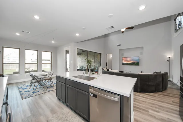 a large kitchen with kitchen island a sink table and chairs