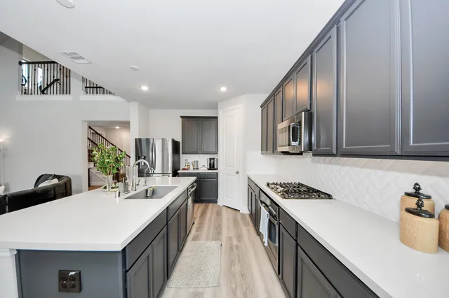 a kitchen with a sink stove and cabinets