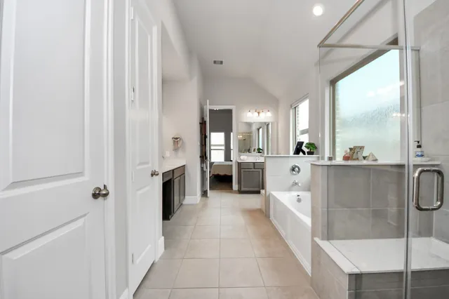 a large white bathroom with a sink a mirror and a bathtub