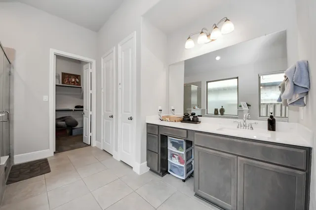 a spacious bathroom with a double vanity sink a mirror and a shower