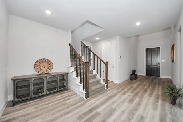 a view of a livingroom with wooden floor and stairs