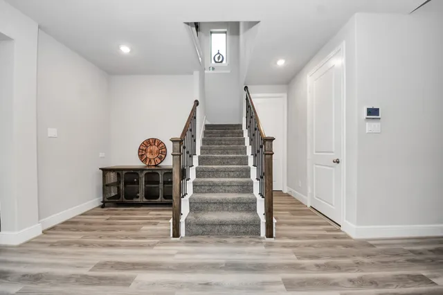 a view of a hallway with wooden floor and white walls