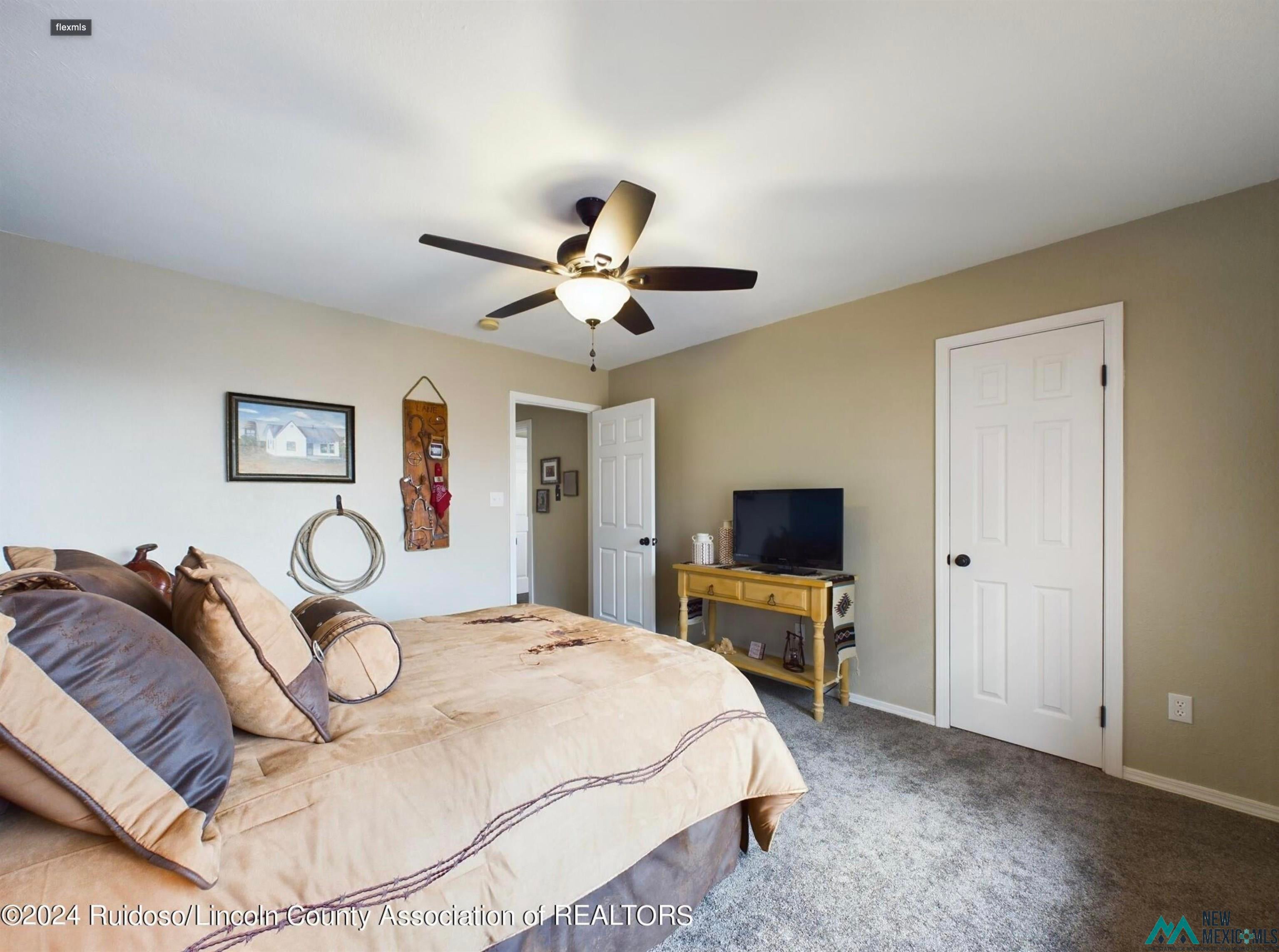 333 Ll Davis Drive Ruidoso, NM 88345 - Photo 22 of 25 Bedroom featuring neutral wall colors, textured carpeting, a ceiling fan with integrated lighting, and multiple paneled doors
