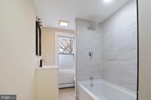 a bathroom with a tub a sink and a mirror