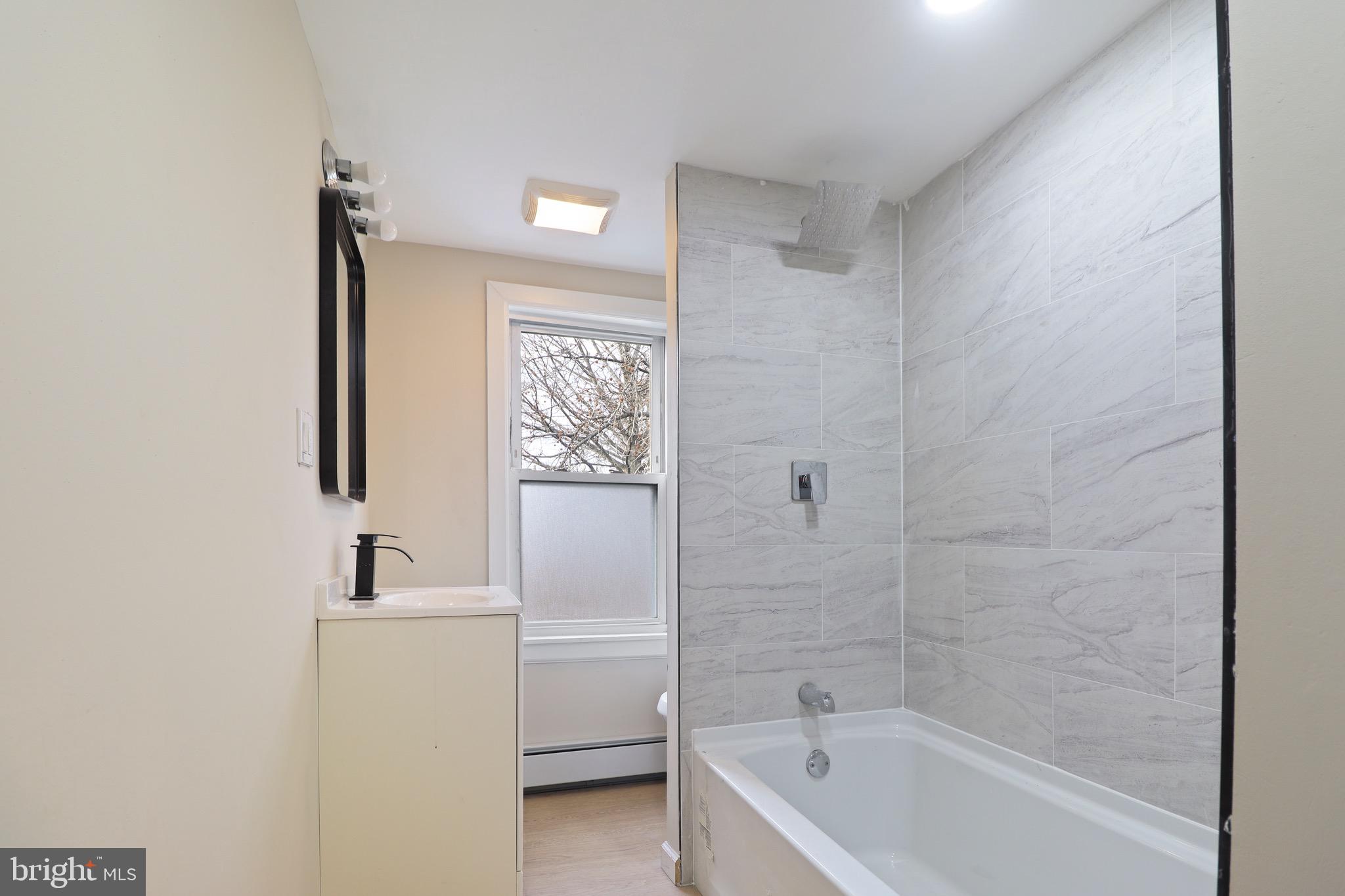 155 7th Street Salem, NJ 08079 - Photo 11 of 20 a bathroom with a tub a sink and a mirror