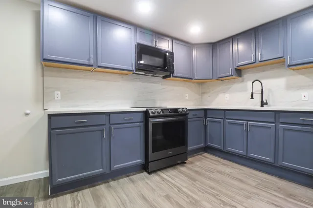 a kitchen with stainless steel appliances granite countertop wooden cabinets a stove top oven a sink and dishwasher