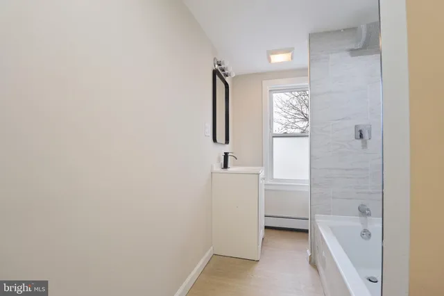 a bathroom with a bathtub sink and mirror