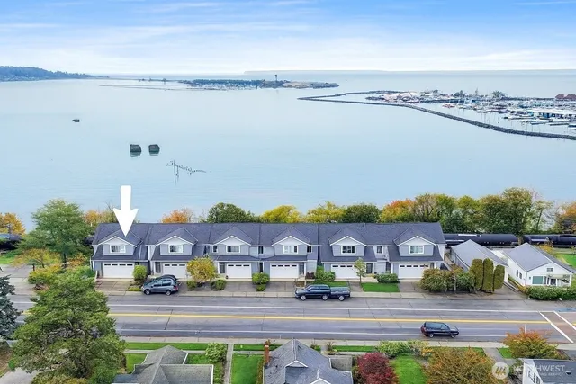 a front view of a house with a yard and lake view