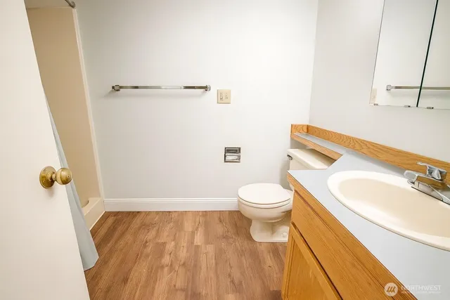 a bathroom with a granite countertop toilet and a sink