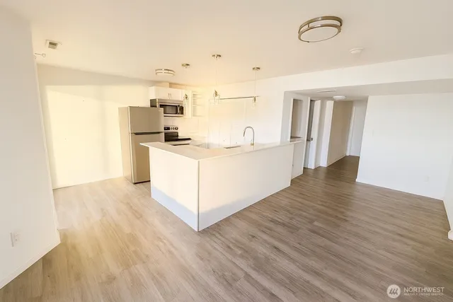 a kitchen with stove and wooden floor