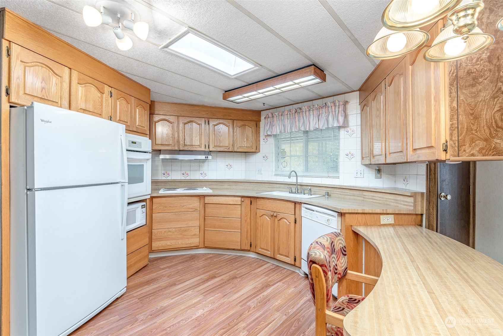 201 Union Avenue Southeast, Unit 99 Renton, WA 98059 - Photo 9 of 30 a kitchen with stainless steel appliances granite countertop a refrigerator a sink dishwasher a stove a dining table and chairs with wooden floor