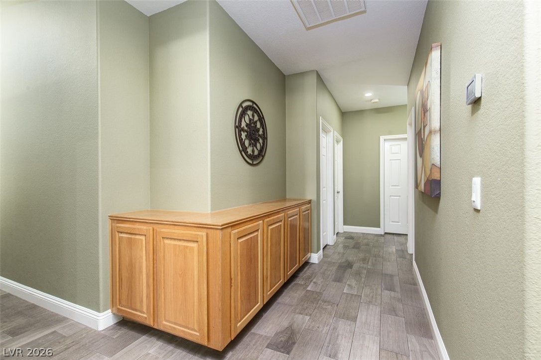 4670 Los Rancheros Avenue Las Vegas, NV 89129 - Photo 22 of 57 A spacious hallway features handsome built-in cabinetry and durable wood-look tile flooring.