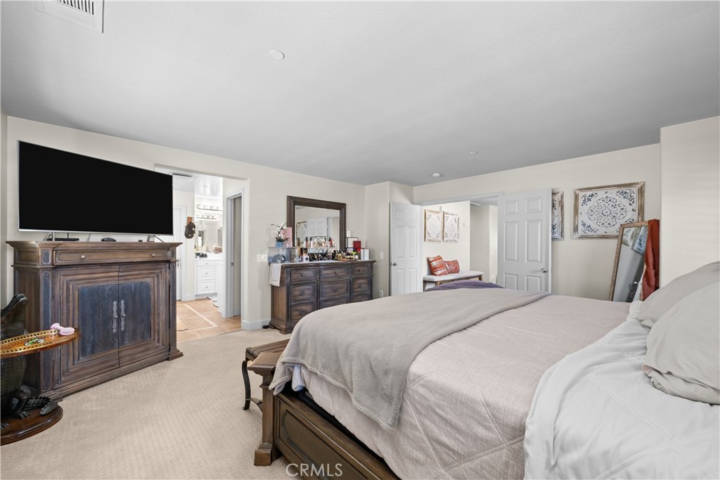 7925 Hemingway Court Fontana, CA 92336 - Photo 14 of 30 a spacious bedroom with a bed and a flat screen tv