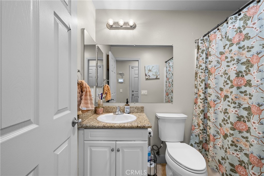 7925 Hemingway Court Fontana, CA 92336 - Photo 22 of 30 a bathroom with a sink a toilet and shower curtain