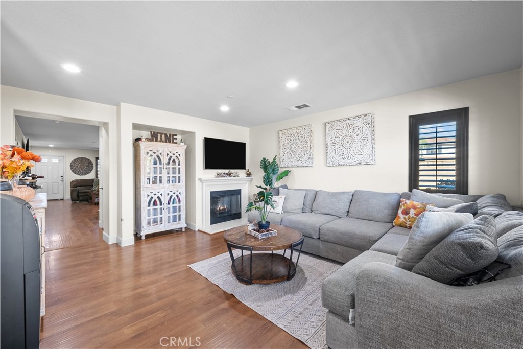 7925 Hemingway Court Fontana, CA 92336 - Photo 9 of 30 a living room with furniture a fireplace and a flat screen tv