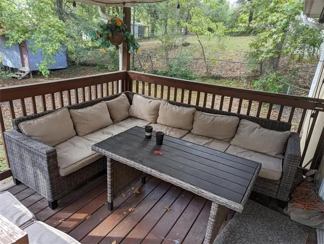a balcony with wooden floor and outdoor seating