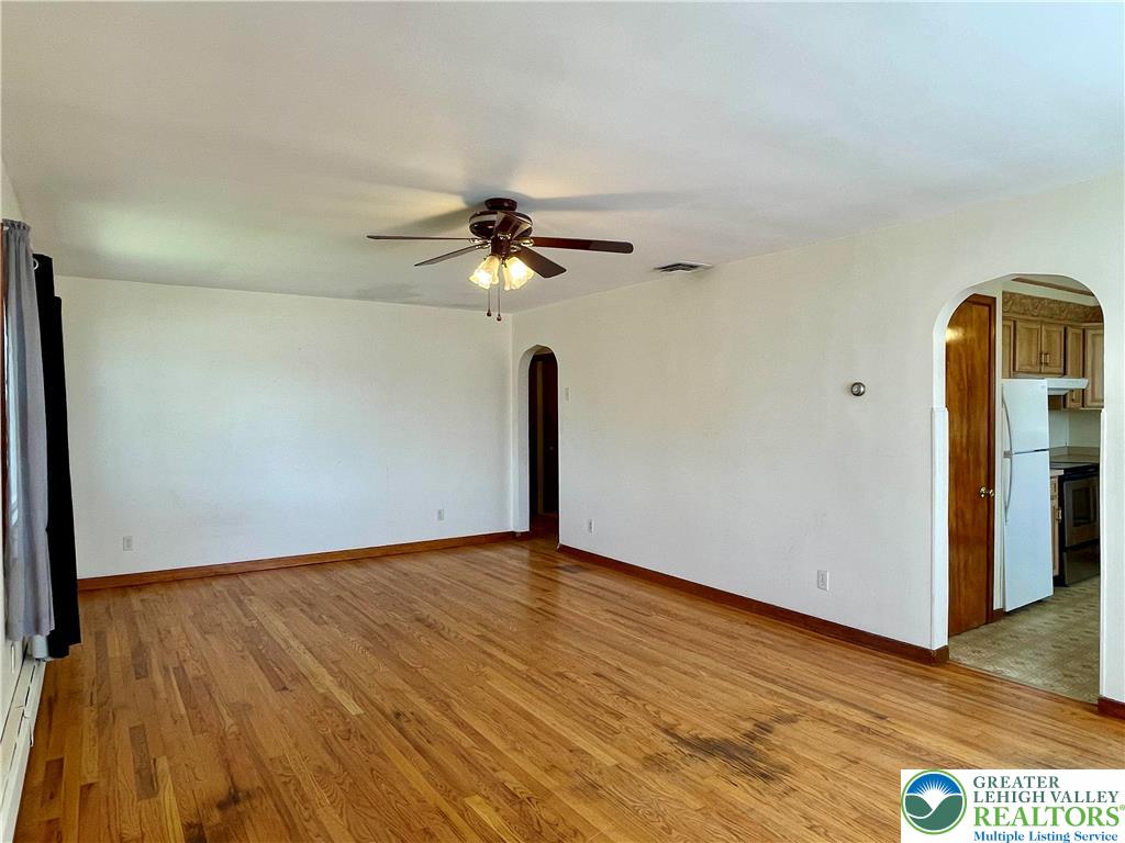 283 Broad Street Bath, PA 18014 - Photo 18 of 36 a view of an empty room with wooden floor and a ceiling fan