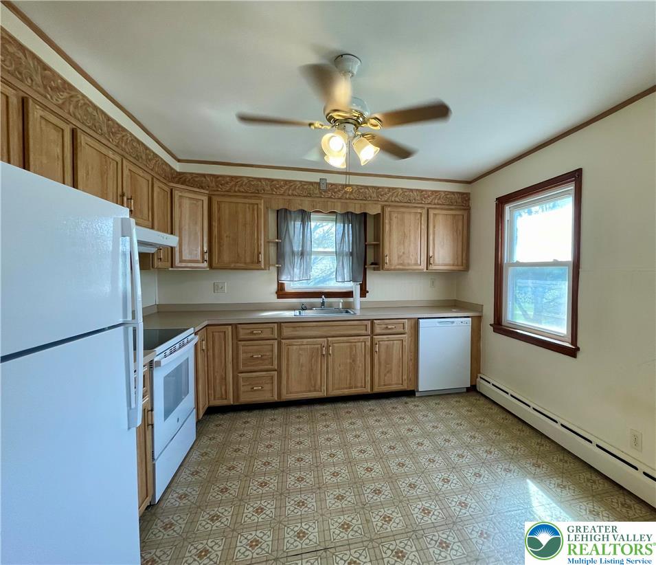 283 Broad Street Bath, PA 18014 - Photo 19 of 36 a kitchen with a refrigerator a sink dishwasher with a dining table and chairs
