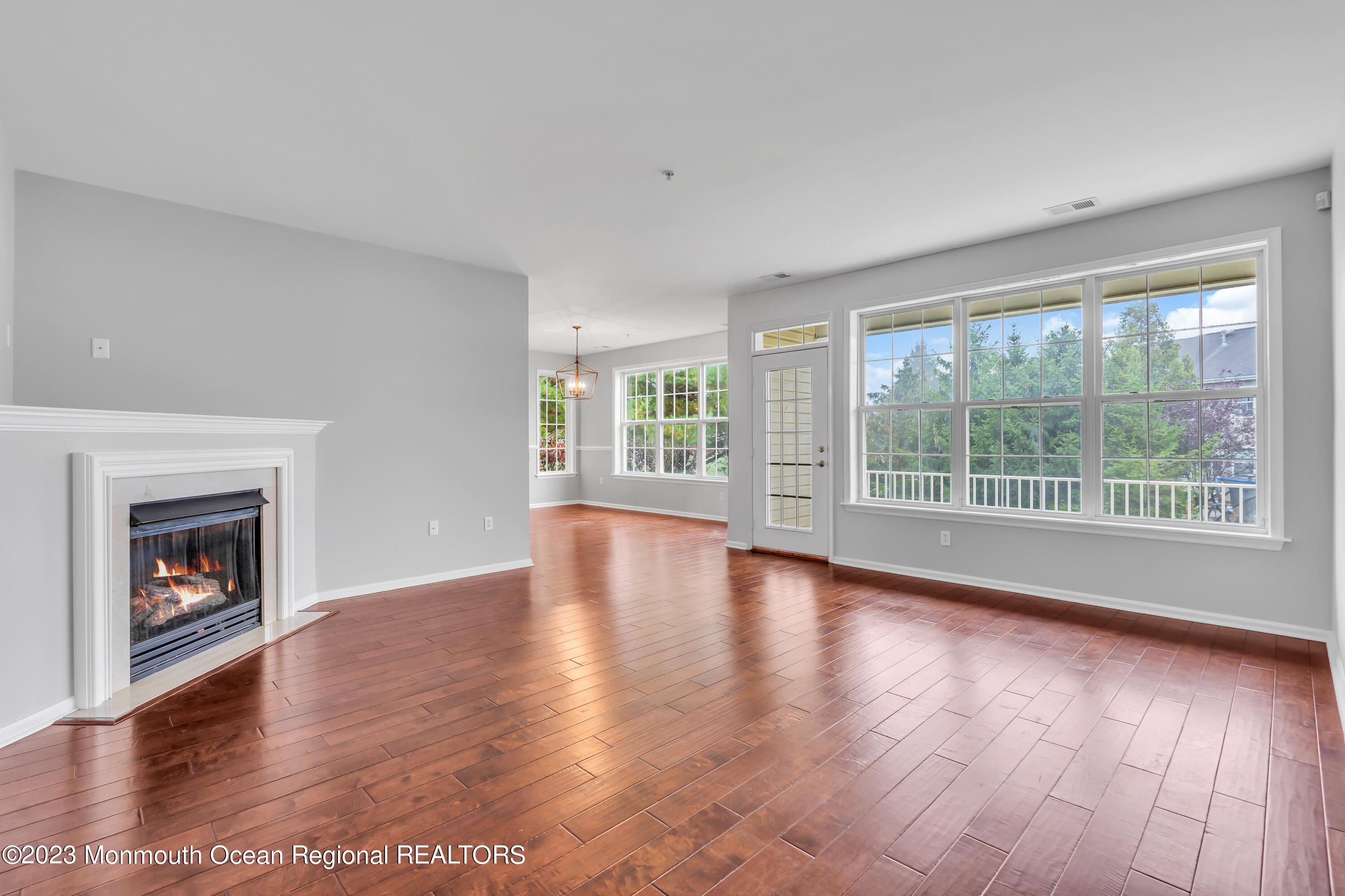 694 St Andrews Place Manalapan, NJ 07726 - Photo 3 of 21 a view of an empty room with wooden floor and a window