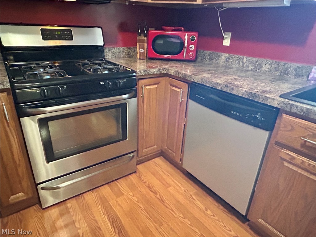 40 East Western Reserve Road, Unit 1 Youngstown, OH 44514 - Photo 8 of 33 Kitchen featuring appliances with stainless steel finishes, dark stone counters, and light wood-type flooring