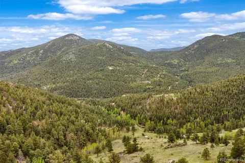 a view of a field with mountains in the background