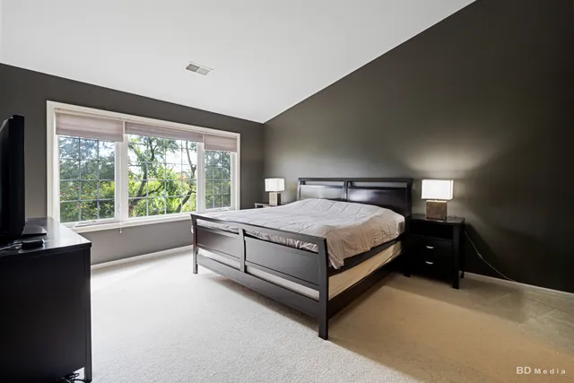 a bedroom with a bed and a large window