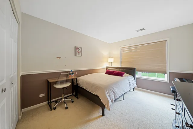 a bedroom with a bed a desk and chair