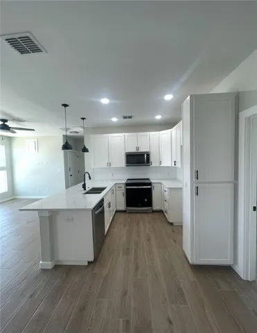 a large kitchen with a center island stainless steel appliances and cabinets