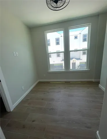 an empty room with wooden floor and window