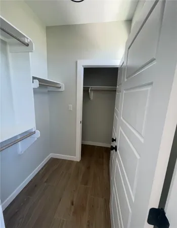 a view of walk in closet with empty racks