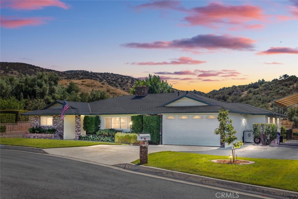 a front view of a house with a garden and a yard
