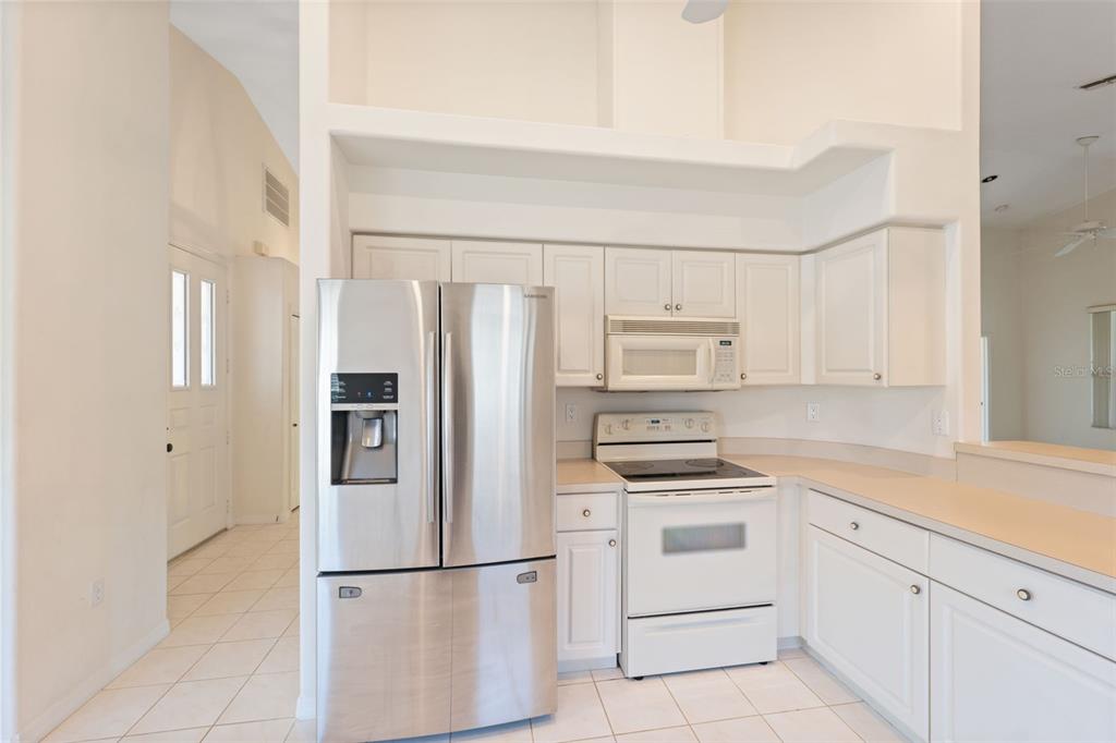 10149 Duffy Circle Weeki Wachee, FL 34613 - Photo 18 of 59 a kitchen with white cabinets and stainless steel appliances