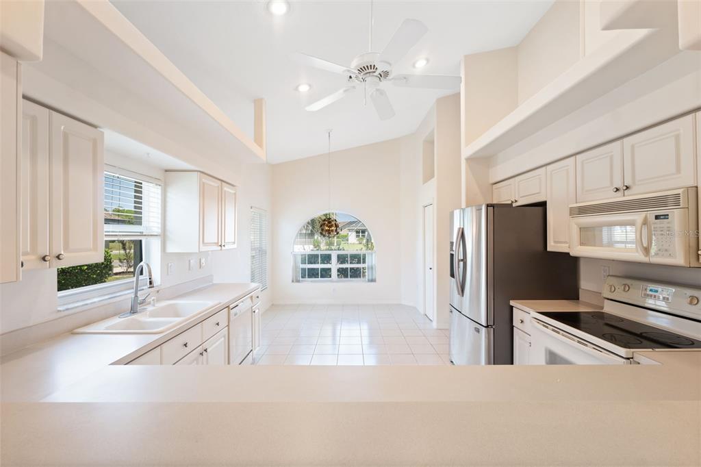 10149 Duffy Circle Weeki Wachee, FL 34613 - Photo 19 of 59 a kitchen with stainless steel appliances a refrigerator a stove a sink a chimney cabinets and furniture