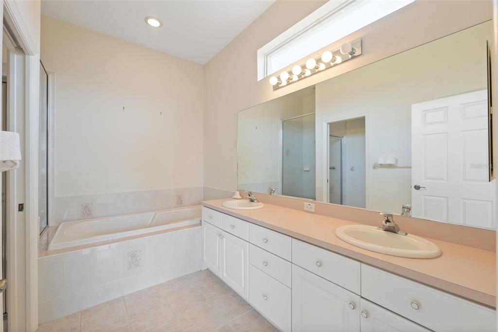 10149 Duffy Circle Weeki Wachee, FL 34613 - Photo 23 of 59 a bathroom with a sink a mirror and a bathtub