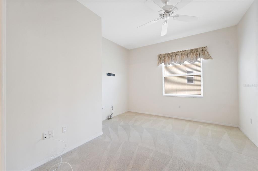 10149 Duffy Circle Weeki Wachee, FL 34613 - Photo 29 of 59 an empty room with a chandelier fan and windows