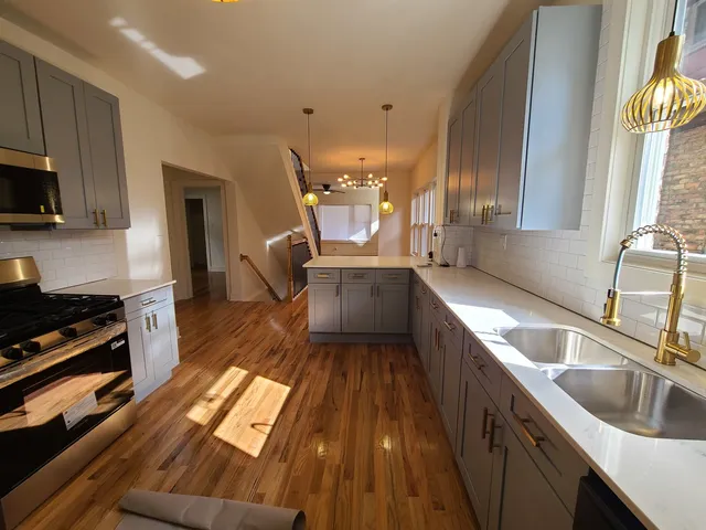 a kitchen with kitchen island granite countertop a sink stove and cabinets