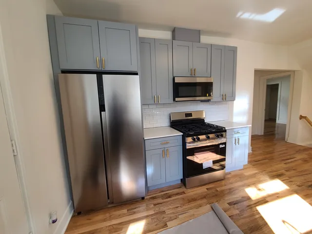 a kitchen with granite countertop a refrigerator stove and microwave