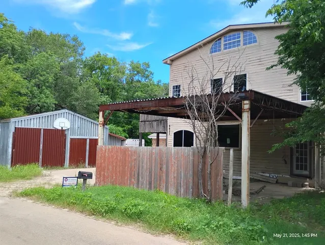 a view of a house with a yard and wooden fence