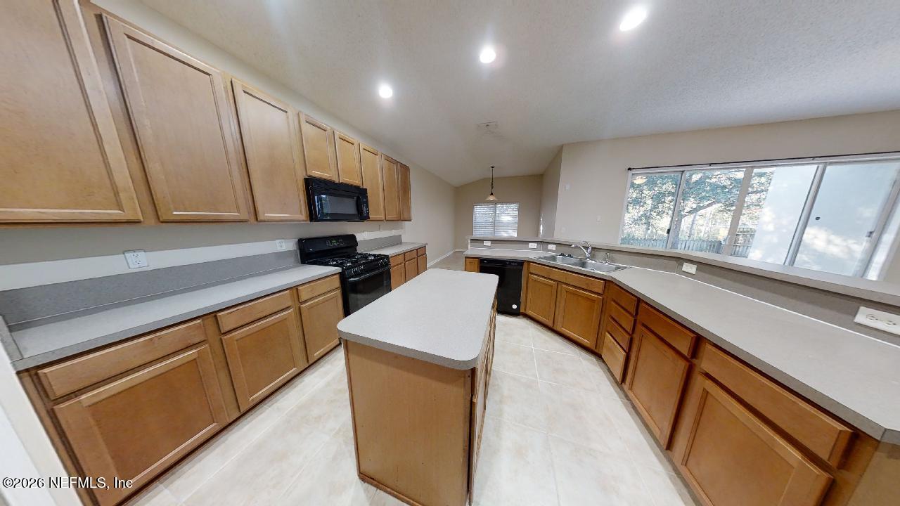 14454 Millhopper Road Jacksonville, FL 32258 - Photo 3 of 44 a kitchen with granite countertop a stove a sink and a microwave