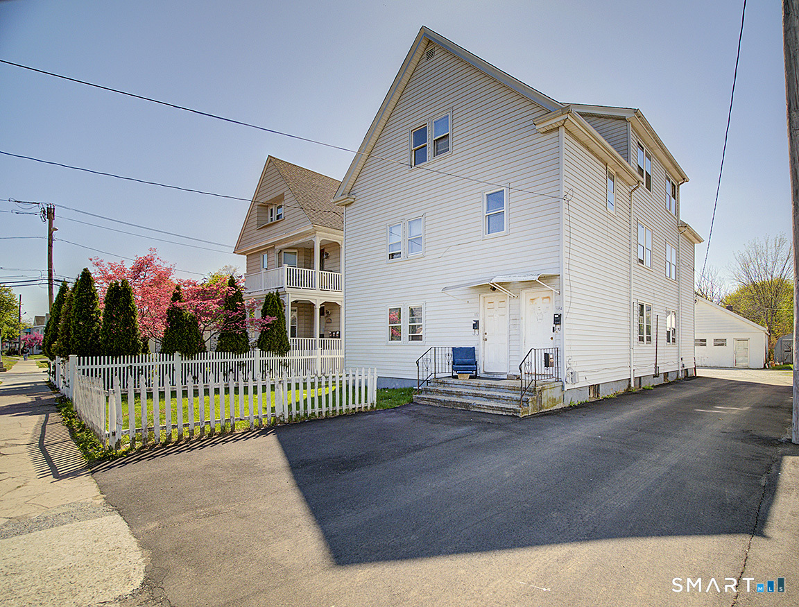 1052 Dixwell Avenue Hamden, CT 06514 - Photo 1 of 25 a front view of a house with a garden