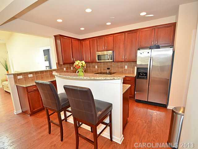 7120 Maricopa Road Charlotte, NC 28277 - Photo 4 of 16 a kitchen with stainless steel appliances granite countertop a refrigerator a sink a stove a dining table and chairs