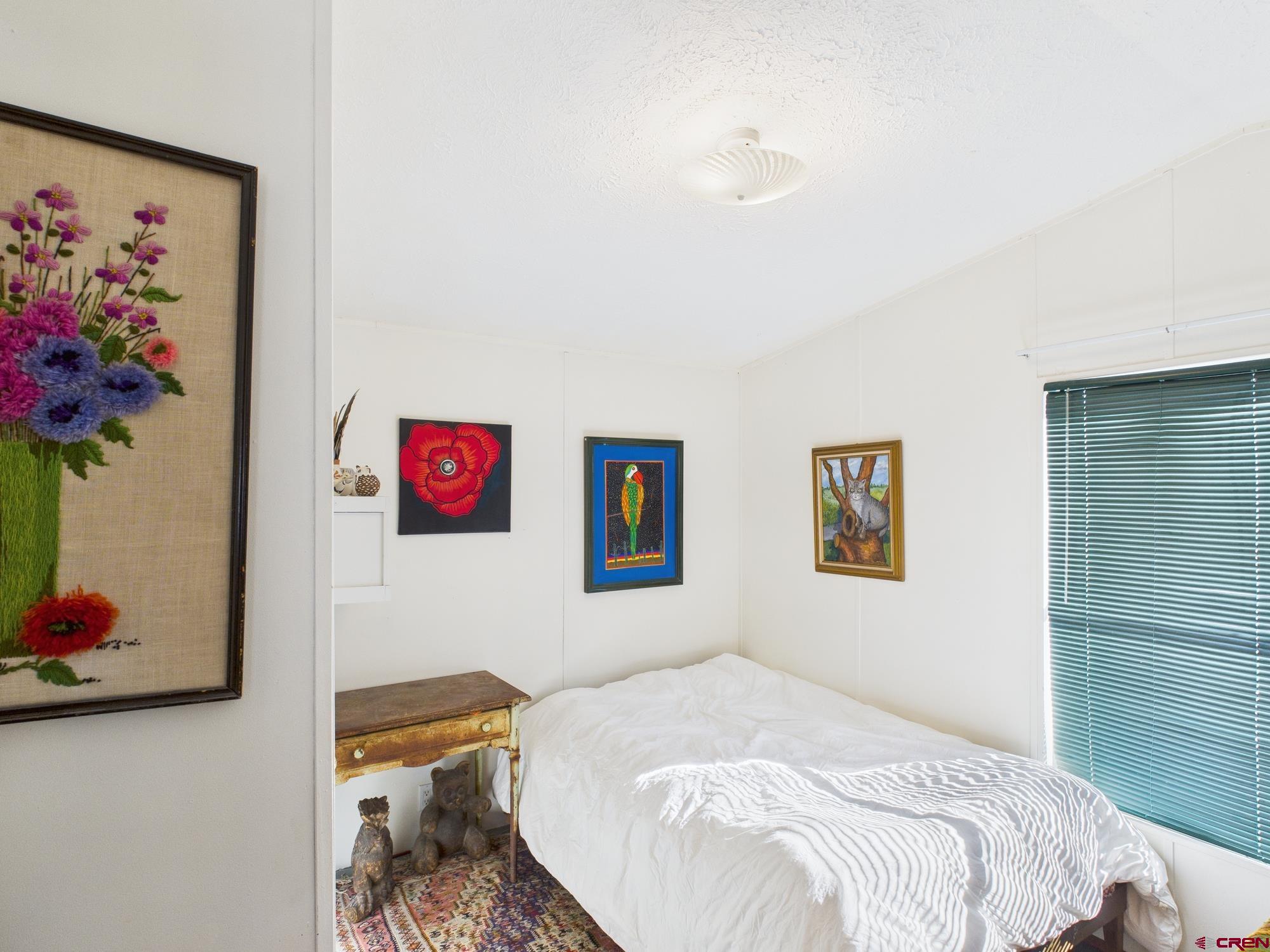 288 Animas View Drive, Unit 9 Durango, CO 81301 - Photo 15 of 20 a bedroom with a bed and a wall painting